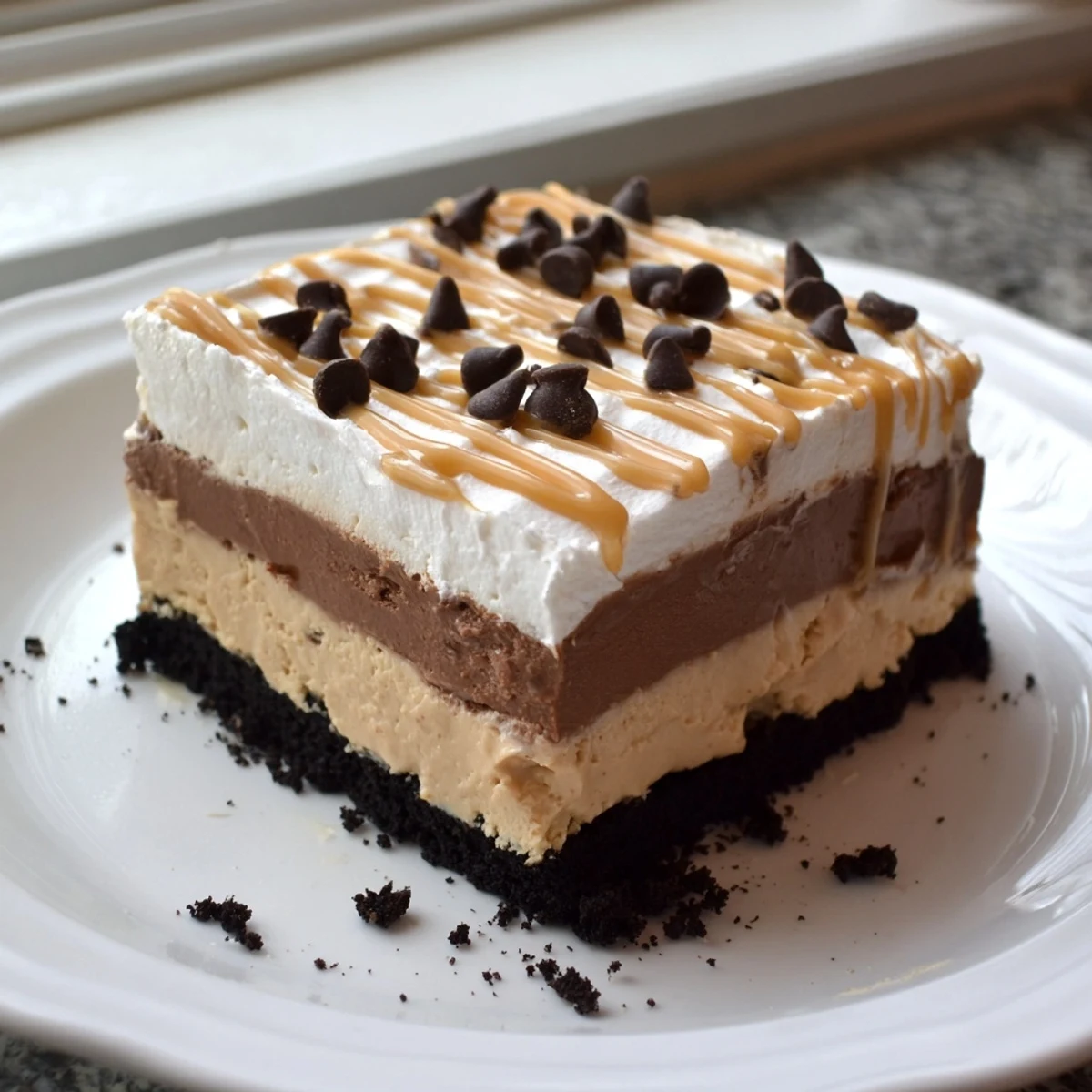 Golden cookie crust visible beneath the glossy peanut butter layered delight dessert