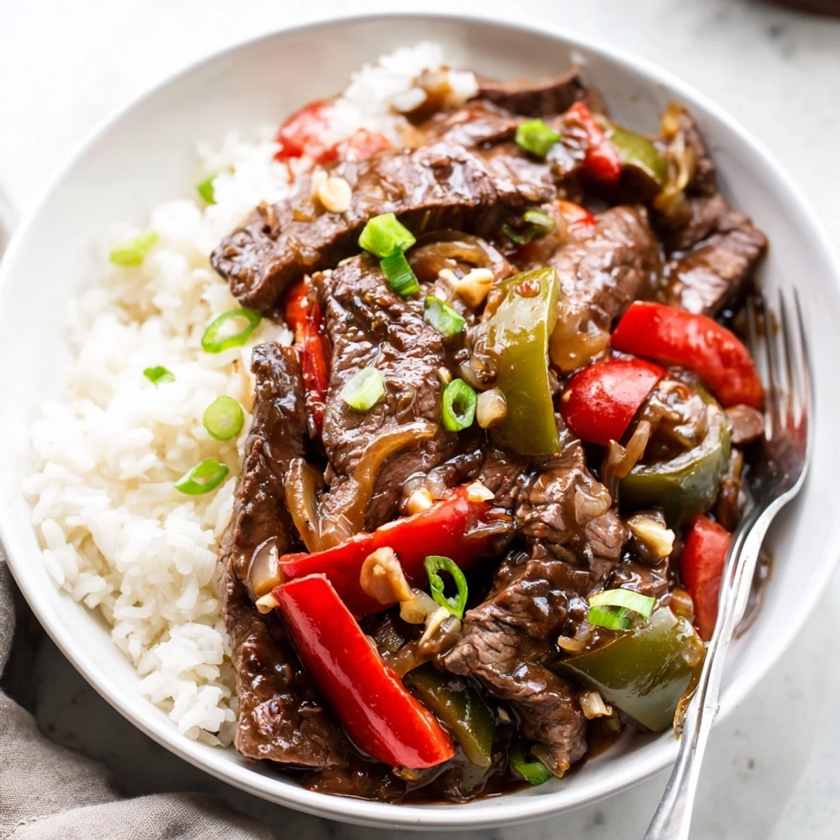 Slow Cooker Pepper Steak with tender beef strips and vibrant bell peppers over fluffy white rice