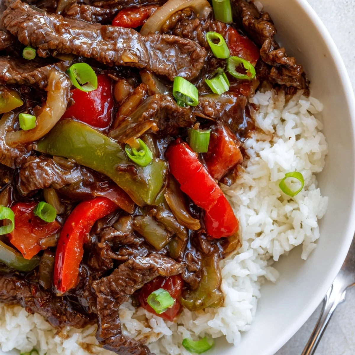 Glossy strips of beef and colorful bell peppers in savory Slow Cooker Pepper Steak sauce