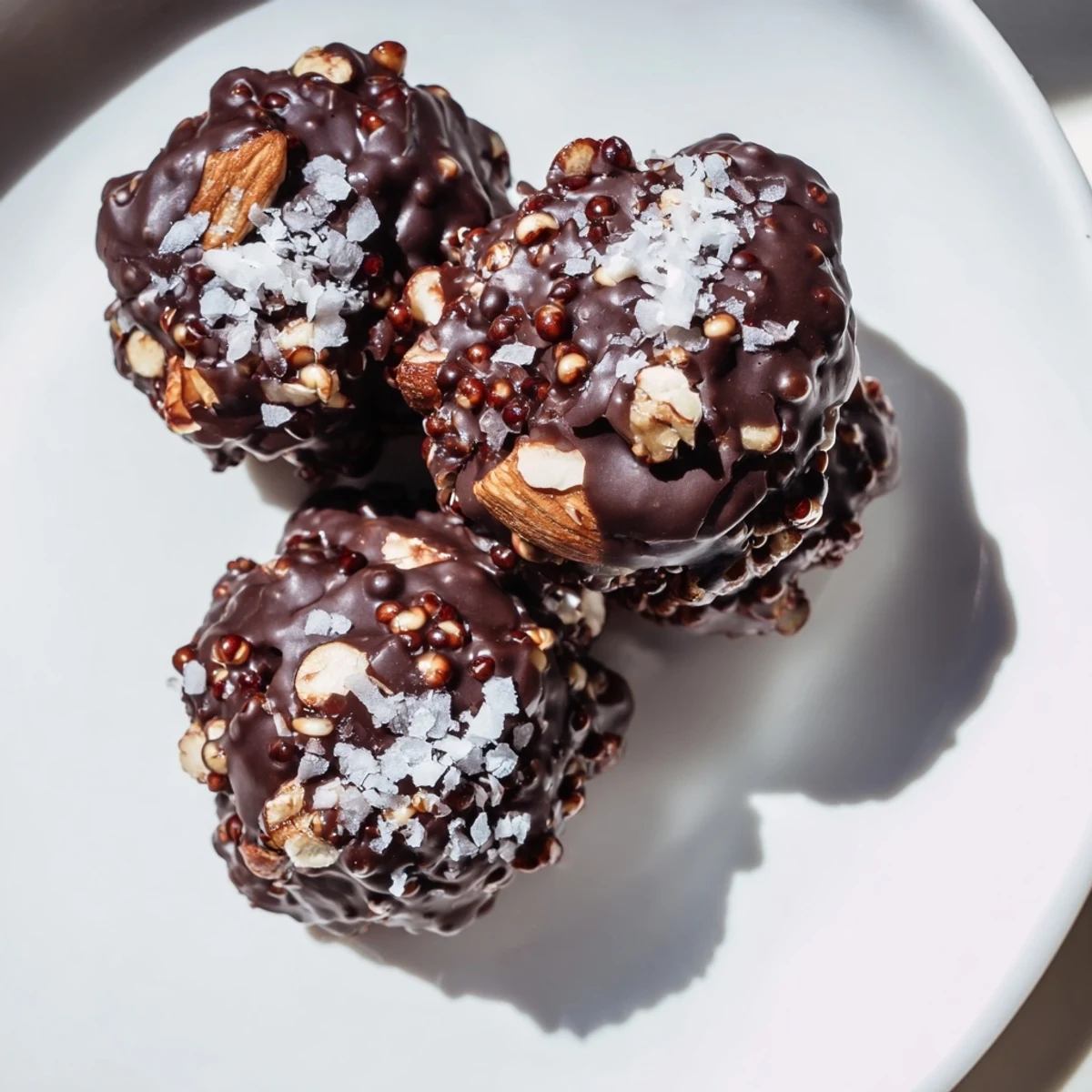 Glossy Chocolate Quinoa Crunch Bites topped with flaky sea salt on parchment paper