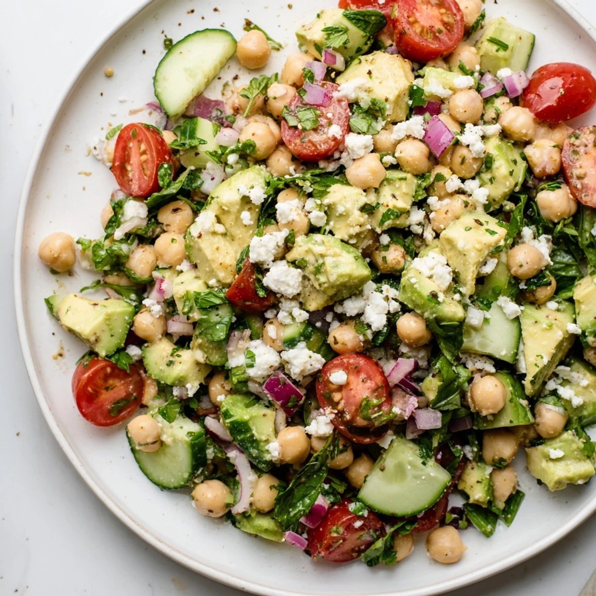 Chickpea feta avocado salad tossed with cherry tomatoes and fresh herbs