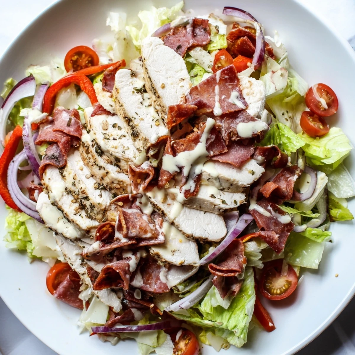 Juicy sliced chicken tops this Italian Grinder Chicken Salad drizzled with creamy zesty dressing