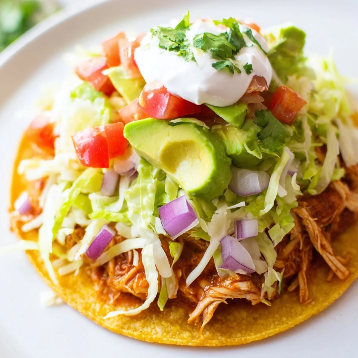Golden Chicken Tostadas piled high with juicy meat, salsa, and sour cream.  