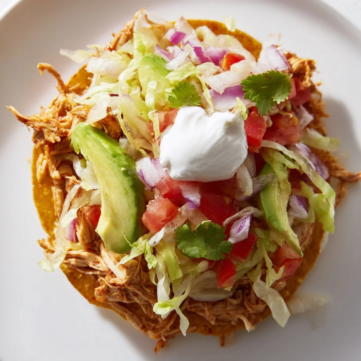 Delicious Chicken Tostadas featuring seasoned chicken, crisp veggies, and melted cheese layers.