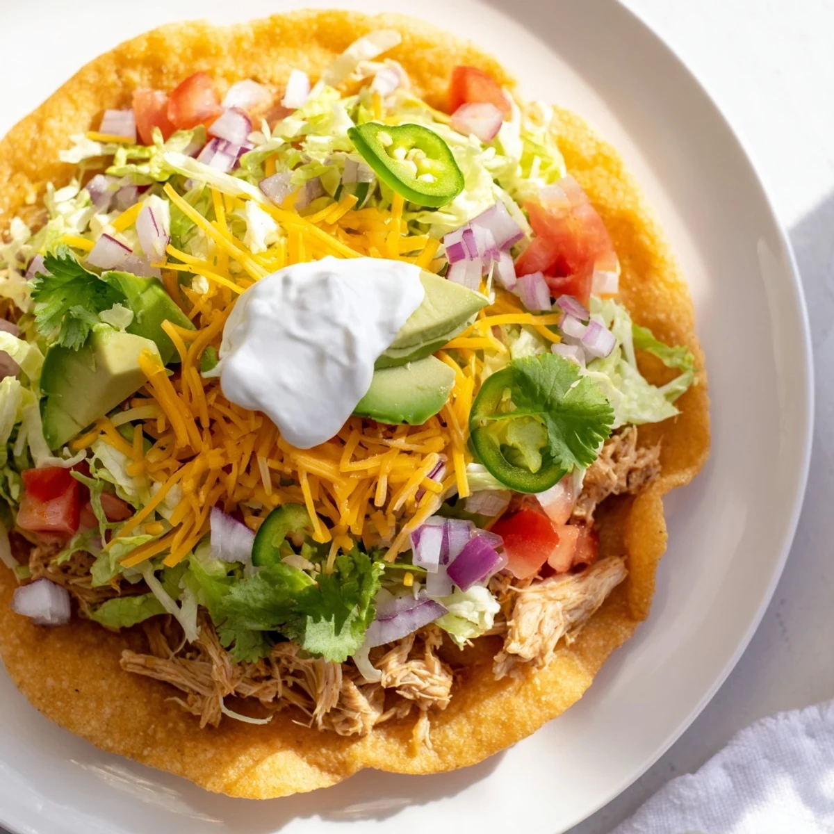 Colorful Chicken Tostadas garnished with cilantro and juicy diced tomatoes