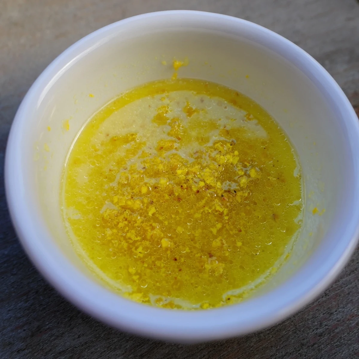 Creamy lemon vinaigrette dressing recipe drizzled over crisp mixed greens in a bowl.  