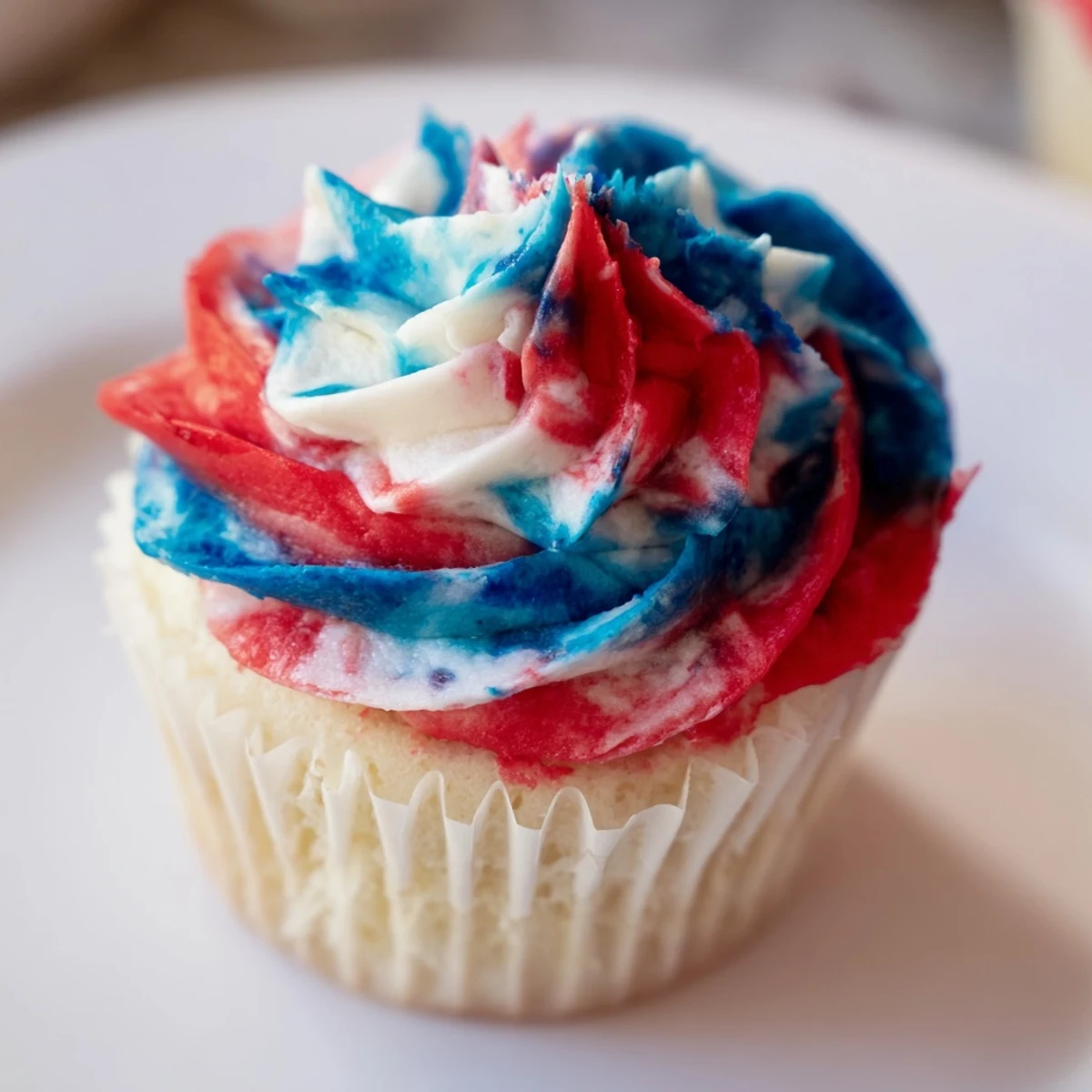 Festive July tie dye cupcakes with vibrant red white blue swirls.  