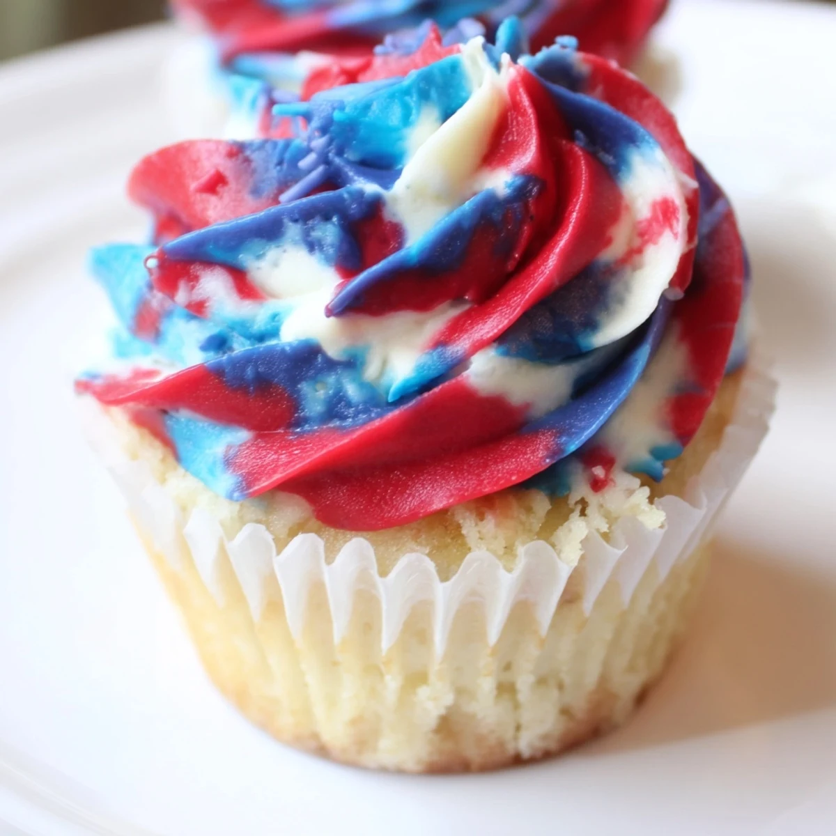 Moist vanilla July tie dye cupcakes topped with colorful buttercream frosting.  