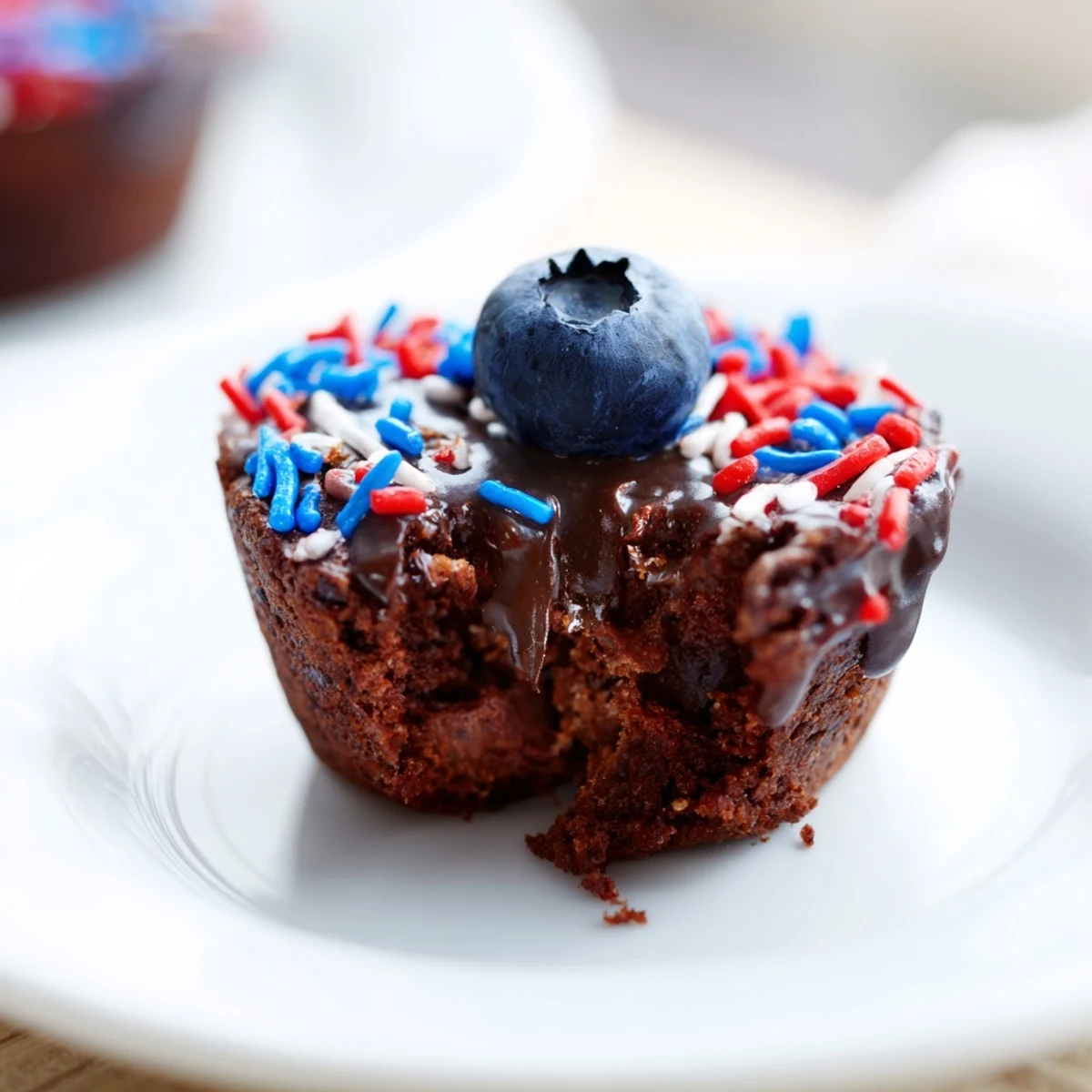 Mini brownie bites decorated for the Fourth of July with colorful sprinkles and fruit.