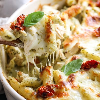 Creamy pesto chicken pasta bake served in a cast iron baking dish